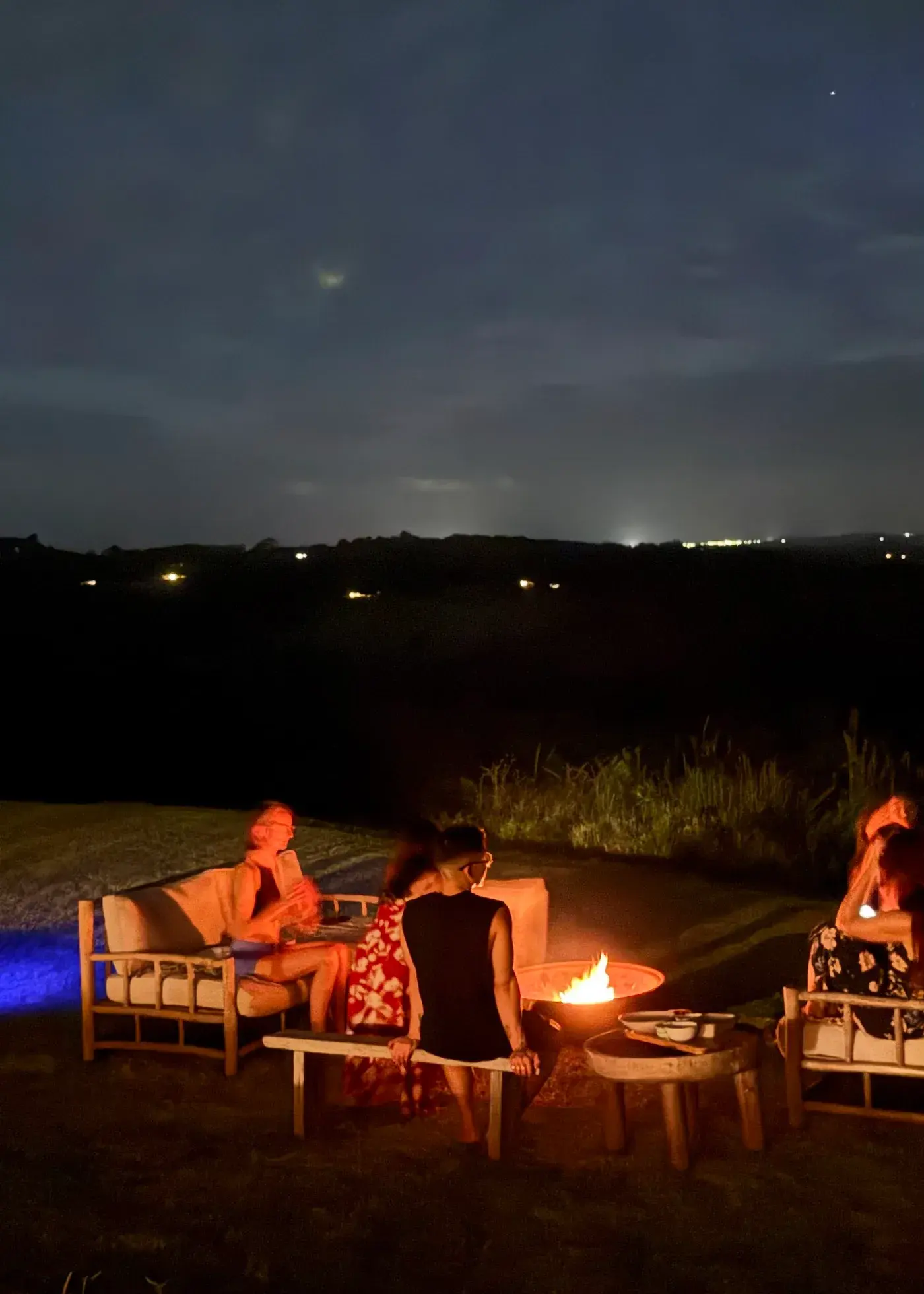 Women gathered around a fire at night